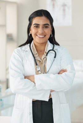 Shot of an attractive young doctor standing alone in her clinic with her arms folded.